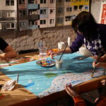 Zdjęcie przedstawia uczestników zajęć plastycznych w trakcie malowania