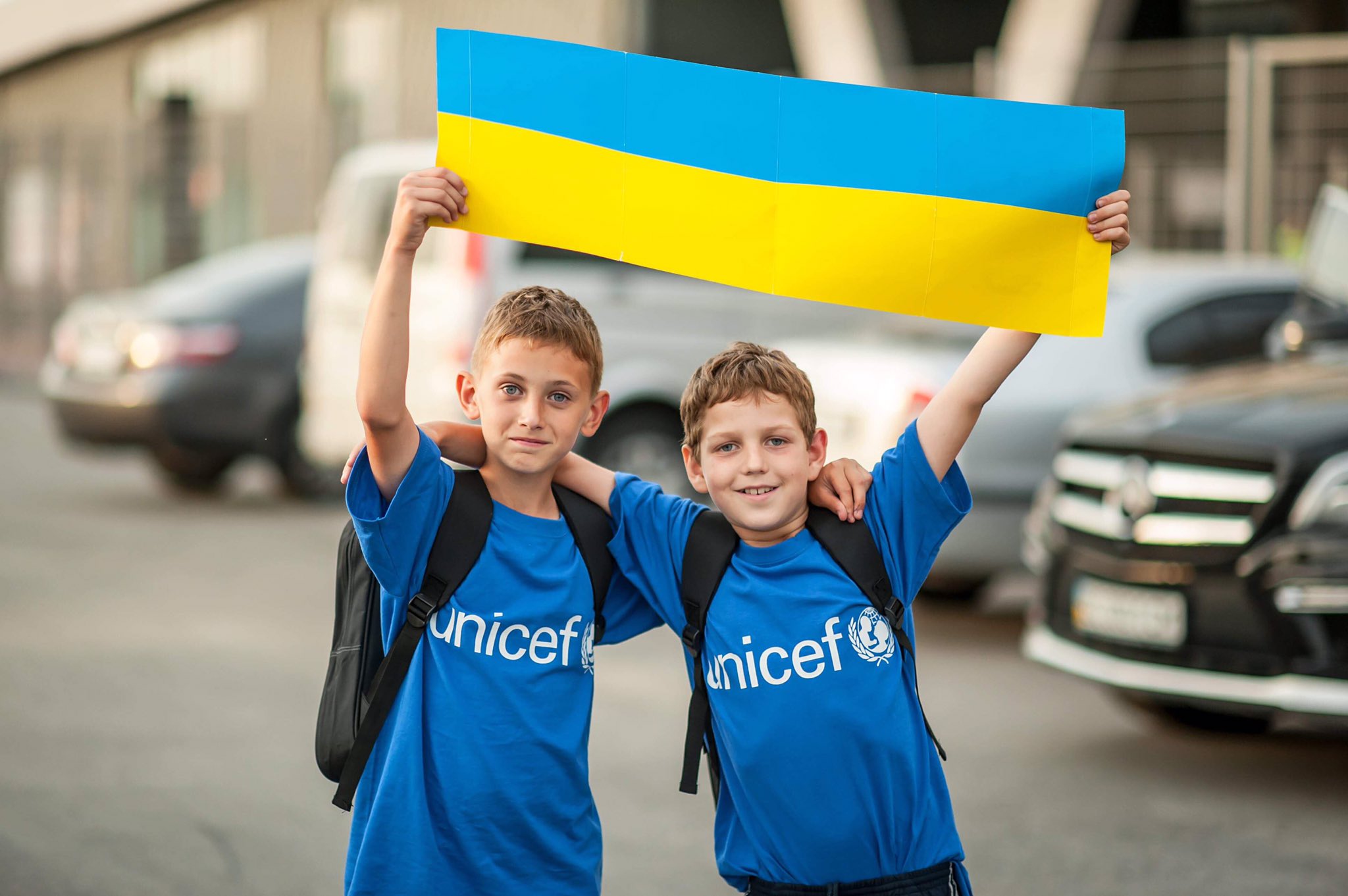 Dwóch chłopców trzymających flagę Ukrainy. Zdjęcie pochodzi z Twittera UNICEF Ukraine